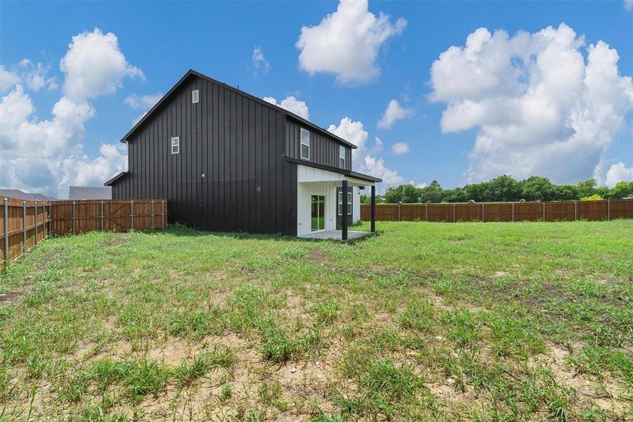 Back of house featuring a fenced backyard, a patio area, and board and batten siding