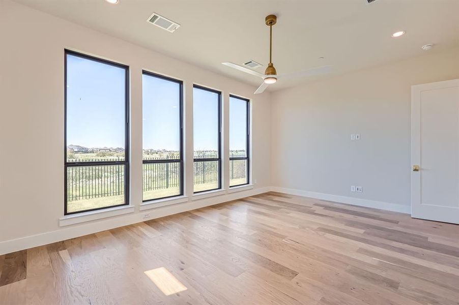 Unfurnished room featuring light wood-type flooring, ceiling fan, and plenty of natural light