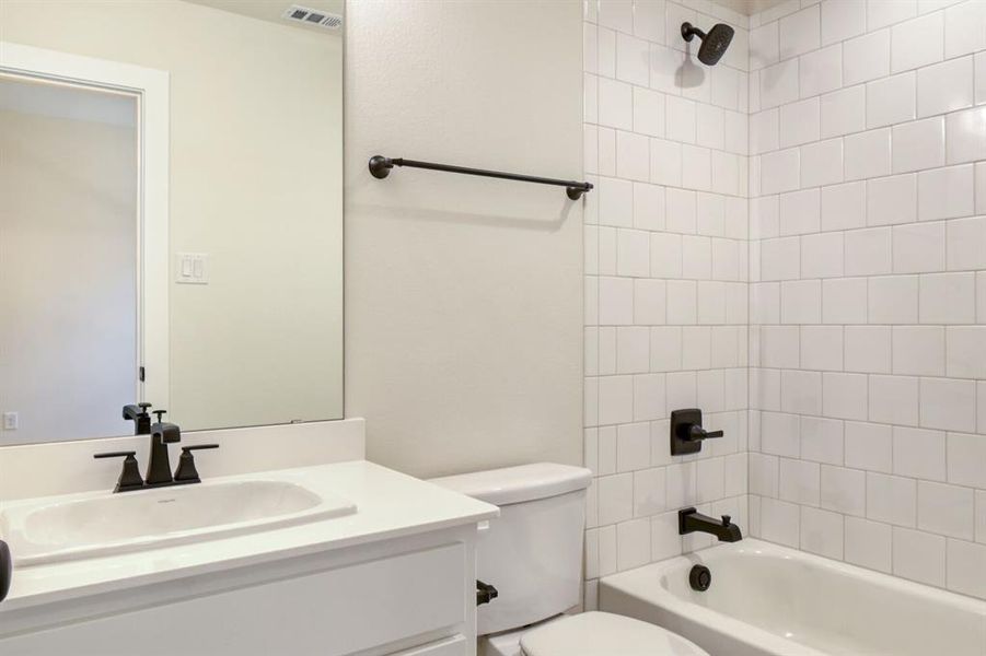 Full bathroom featuring vanity and shower / bath combination Full bathroom featuring vanity and shower / bath combination