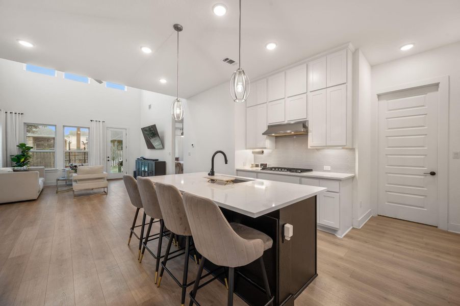 Open concept  kitchen/living area quartz counters with barstool seating