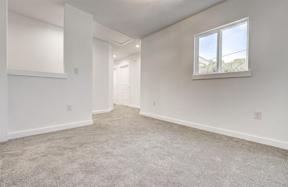 Spare room featuring light carpet, attic access, and recessed lighting