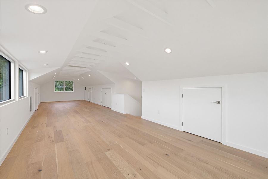 Additional living space featuring vaulted ceiling, light wood-type flooring, and recessed lighting Additional living space featuring vaulted ceiling, light wood-type flooring, and recessed lighting
