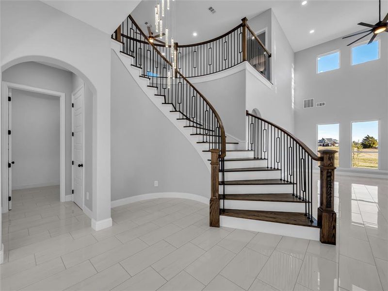 Staircase featuring plenty of natural light, stylish light fixture, and high ceilings. Staircase featuring plenty of natural light, stylish light fixture, and high ceilings.