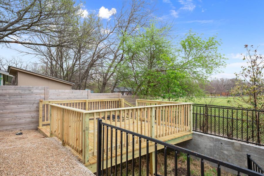 Wooden deck with a fenced backyard