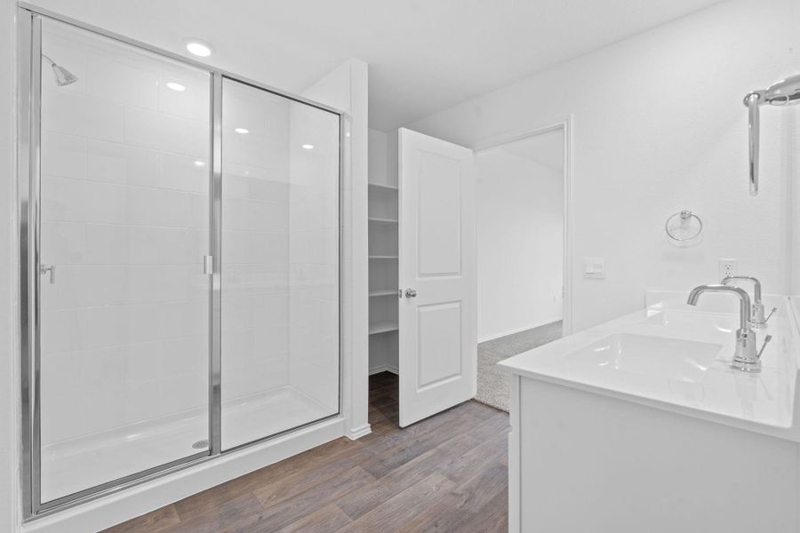 Bathroom featuring double vanity, a stall shower, and dark wood-style flooring Bathroom featuring double vanity, a stall shower, and dark wood-style flooring