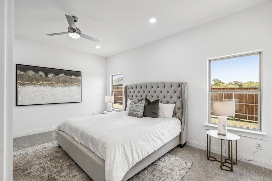 Carpeted bedroom featuring ceiling fan