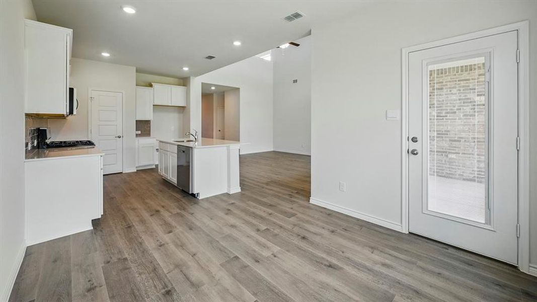 Open-concept living space with wood-finish flooring extending throughout Open-concept living space with wood-finish flooring extending throughout