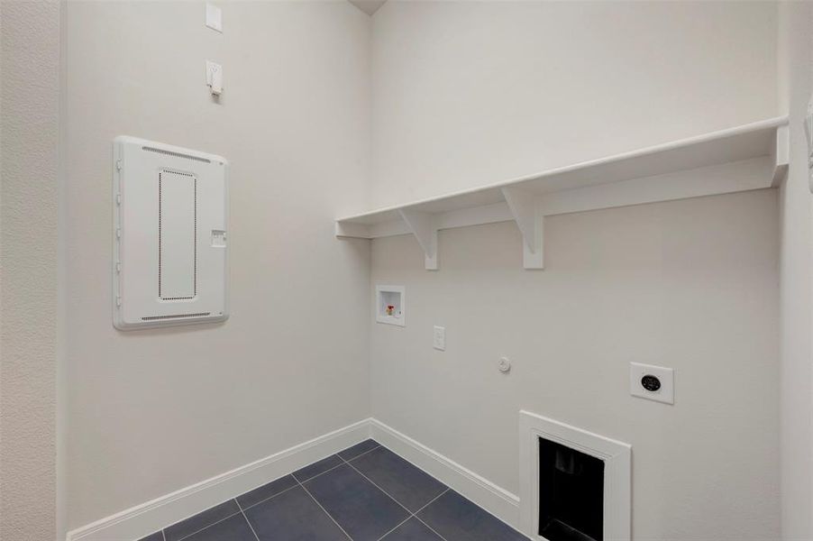 Laundry room featuring gas dryer hookup, hookup for a washing machine, dark tile patterned flooring, and electric dryer hookup