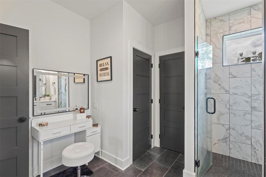 Spa-inspired primary bath featuring dual vanities, designer lighting, sleek black hardware, and a spacious walk-in shower with refined tilework—creating a polished, luxury retreat with modern country elegance.