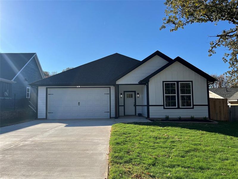 View of front facade with a front lawn and a garage