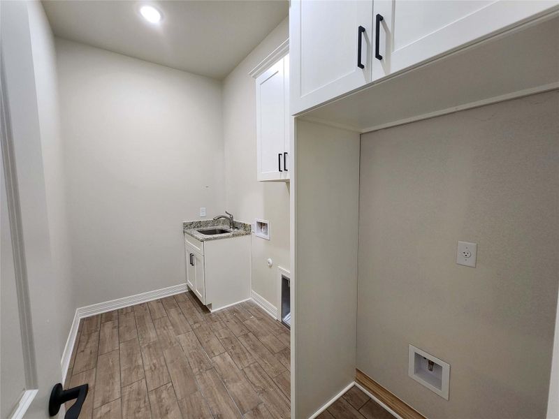 Laundry area featuring wood finish floors, hookup for a washing machine, cabinet space, recessed lighting, and gas dryer hookup