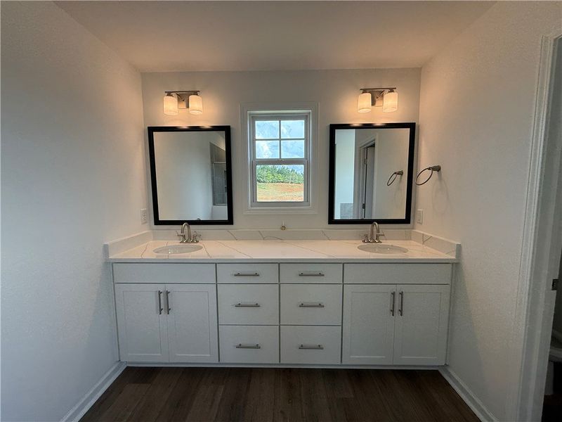 A well-appointed primary bathroom features a doubl A well-appointed primary bathroom features a doubl