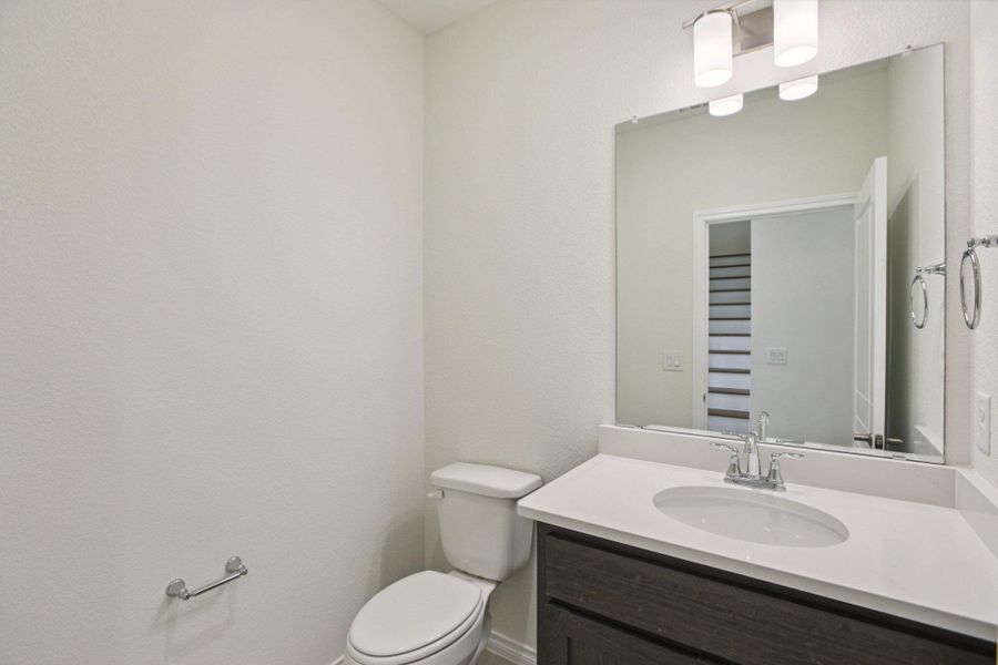 Half bathroom with vanity and a textured wall