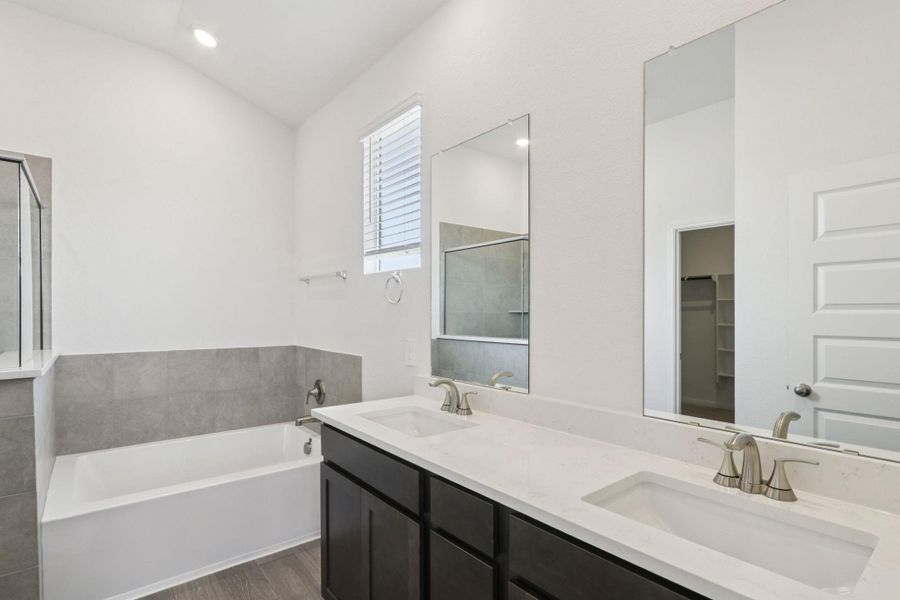 Full bathroom featuring a bath, double vanity, dark wood finished floors, and recessed lighting Full bathroom featuring a bath, double vanity, dark wood finished floors, and recessed lighting