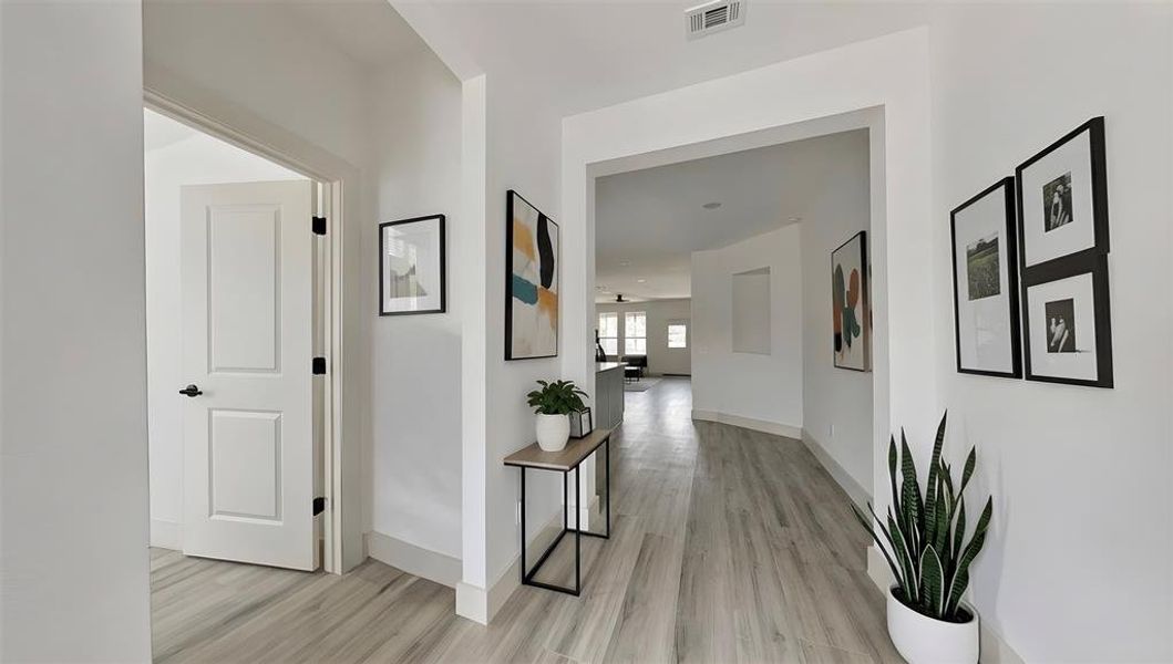 Corridor with light wood-type flooring and baseboards
