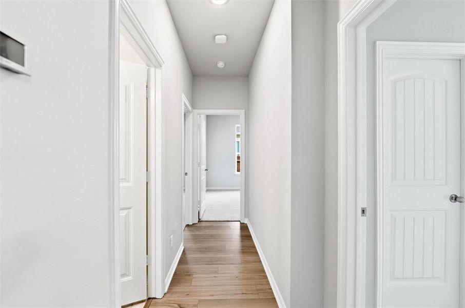Hallway with baseboards and light wood finished floors