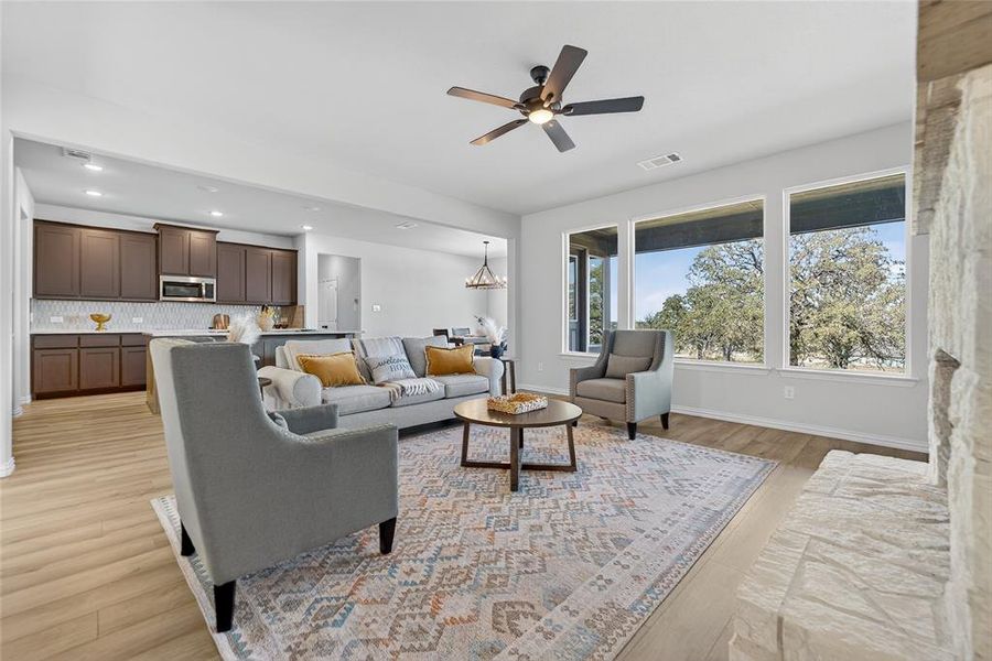 Living area featuring a chandelier, light wood-style floors, ceiling fan, and recessed lighting Living area featuring a chandelier, light wood-style floors, ceiling fan, and recessed lighting