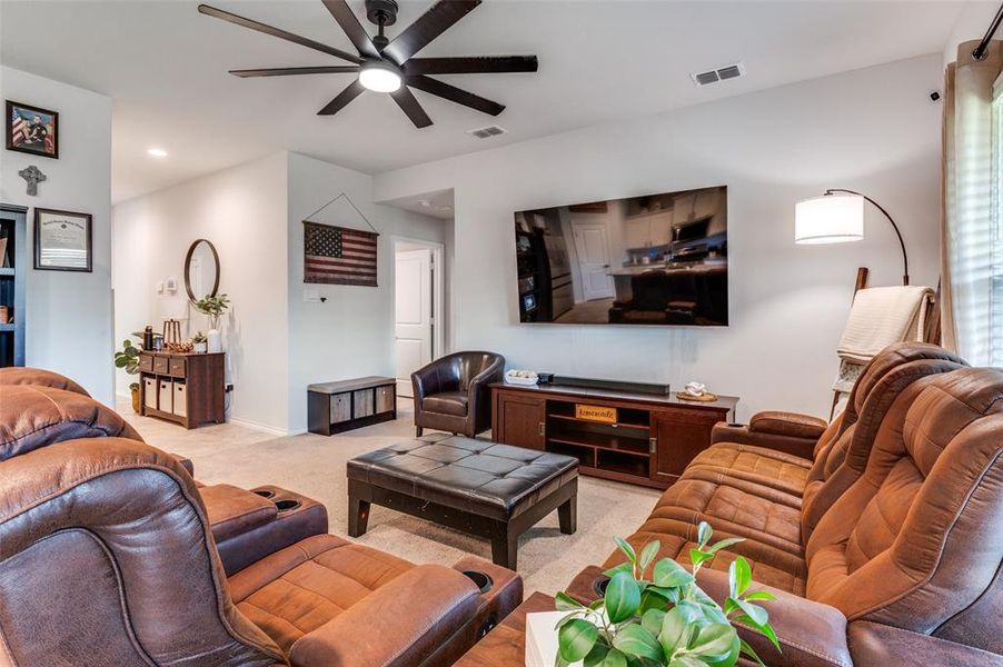 Living area featuring a ceiling fan, light colored carpet, and recessed lighting