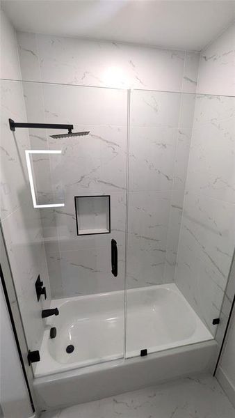 Bathroom featuring  shower combination and marble finish floor