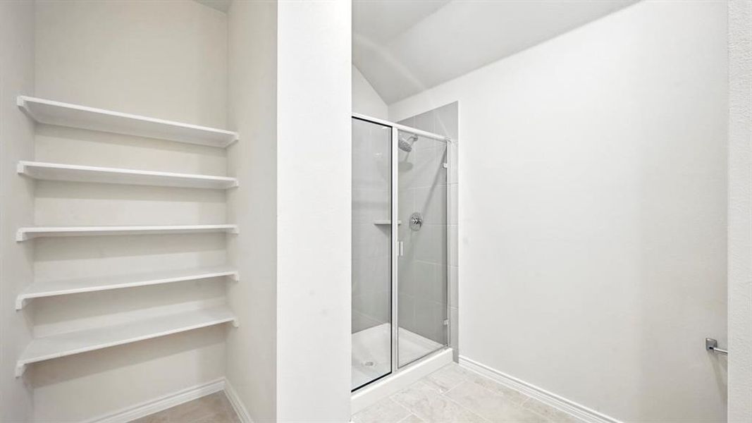 Full bath featuring vaulted ceiling and a stall shower