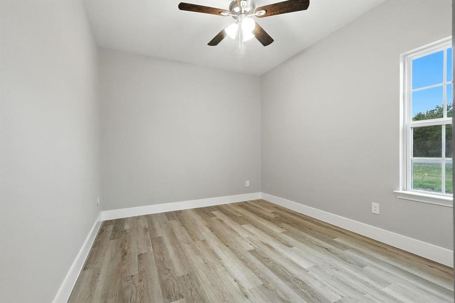 Unfurnished bedroom featuring light wood-style floors and a ceiling fan Unfurnished bedroom featuring light wood-style floors and a ceiling fan