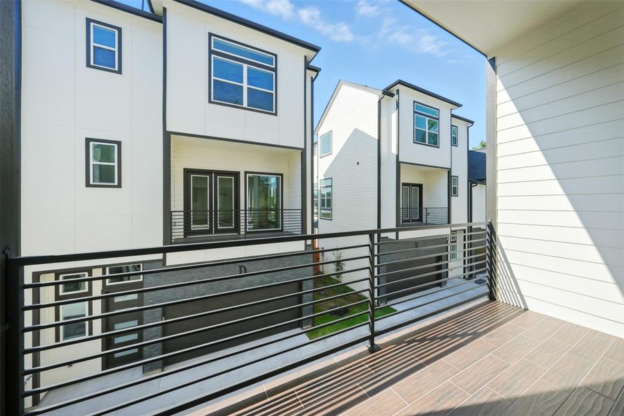 Private second-floor balcony with modern metal railing, offering a perfect outdoor space to relax or entertain. This low-maintenance balcony features durable tile flooring and a clean, modern design for seamless indoor-outdoor living. Private second-floor balcony with modern metal railing, offering a perfect outdoor space to relax or entertain. This low-maintenance balcony features durable tile flooring and a clean, modern design for seamless indoor-outdoor living.