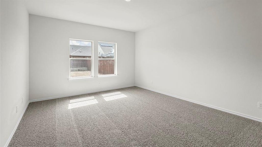 Carpeted room featuring two windows and white baseboards