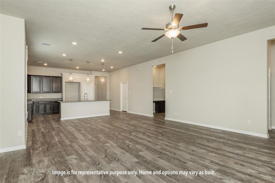 Unfurnished living room featuring dark wood-style floors, ceiling fan, and recessed lighting