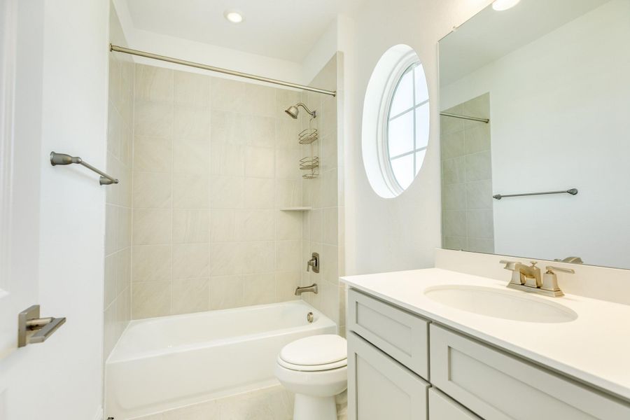 Upstairs secondary bathroom shared by two bedrooms. Features include a tub/shower combination, granite countertops, and a transom window.