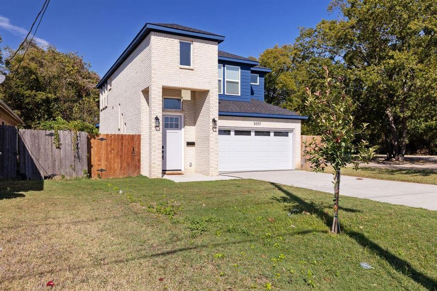 View of front of property featuring a front yard and a garage