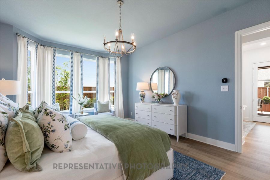 Bedroom with wood finished floors and a chandelier