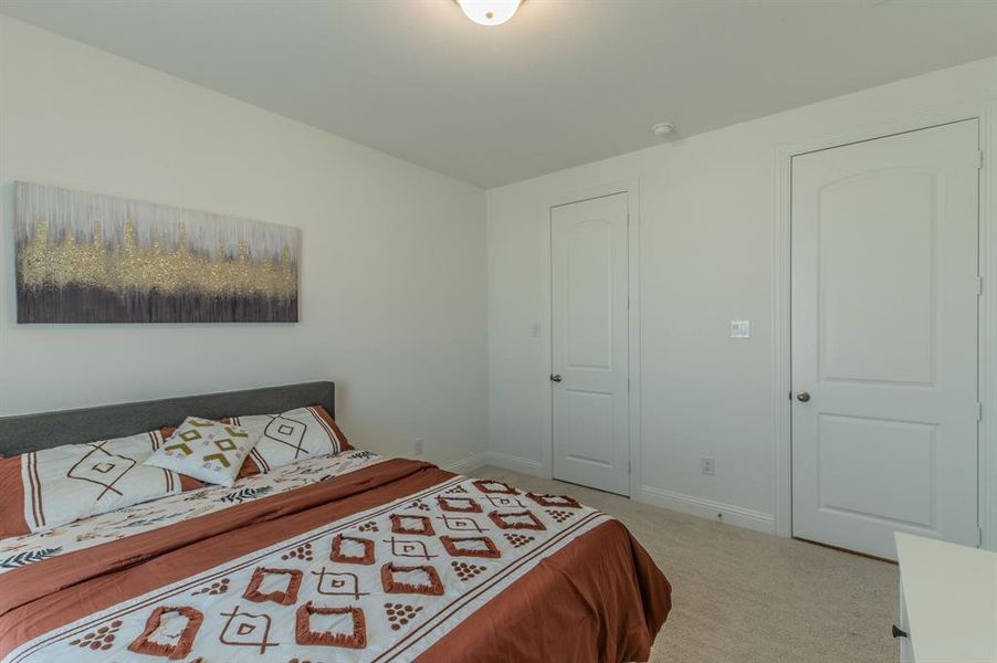 Carpeted room with light neutral walls, recessed ceiling lighting, and two panel doors with chrome hardware