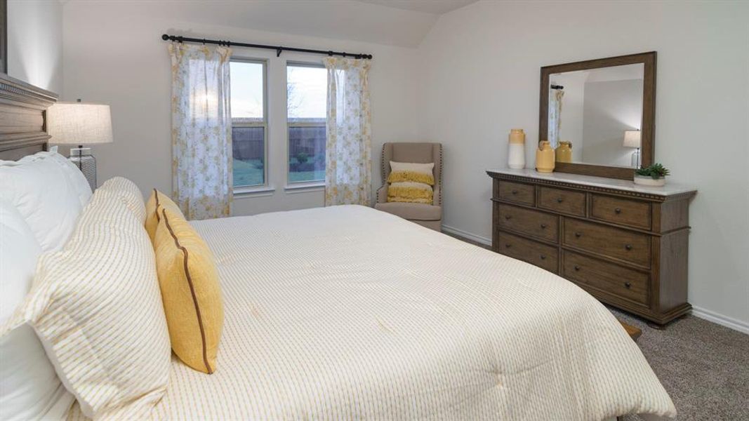 Bedroom with dark carpet and vaulted ceiling