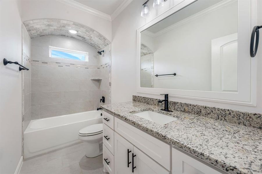 Full bathroom featuring toilet, shower / bathing tub combination, tile patterned floors, crown molding, and vanity