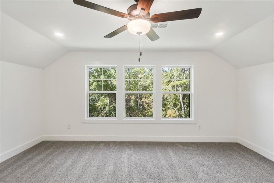 A wall of windows frames leafy outdoor views in th