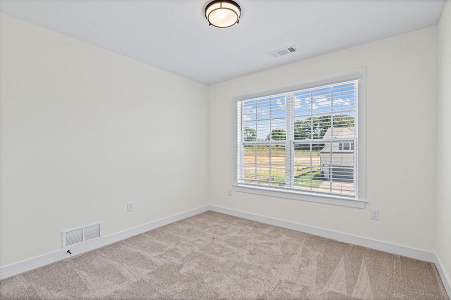 Neutral-toned room featuring a large window with horizontal blinds, providing ample natural light Neutral-toned room featuring a large window with horizontal blinds, providing ample natural light