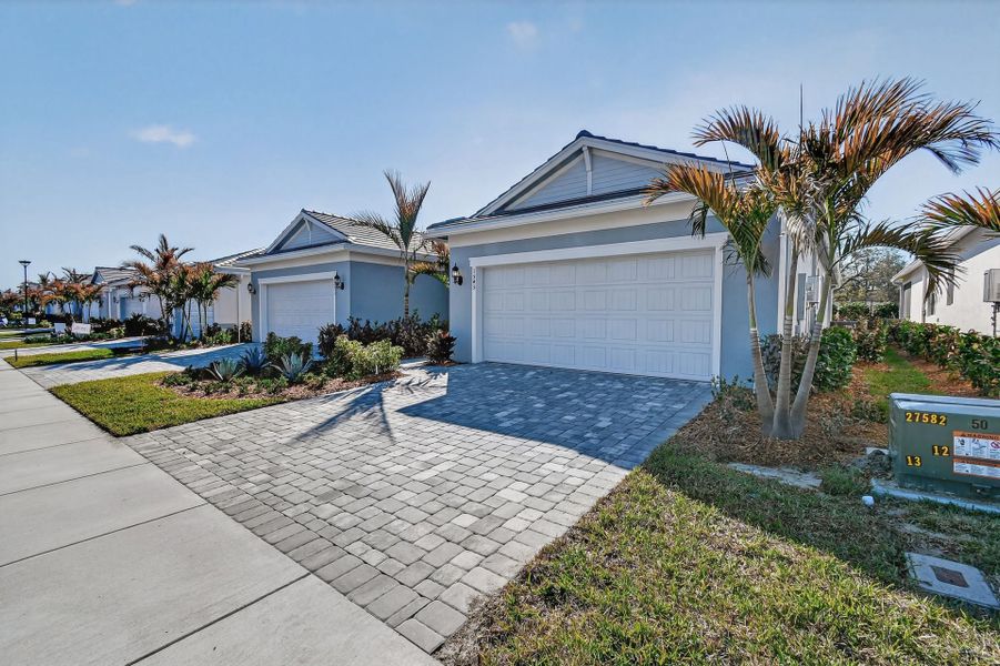 Front exterior of a new home in Costa Pointe, Vero Beach, FL, highlighting curb appeal (Image 30).