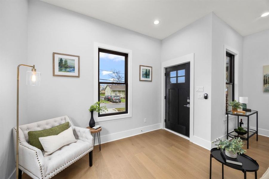 Charming entryway with a stylish black door, abundant natural light with an inviting first impression.