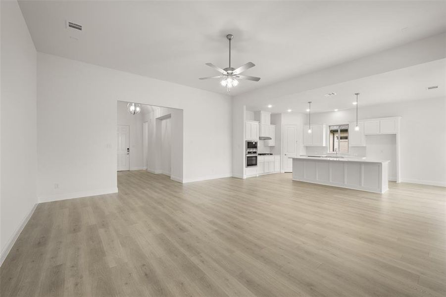 Unfurnished living room featuring light wood-style flooring, ceiling fan, and recessed lighting Unfurnished living room featuring light wood-style flooring, ceiling fan, and recessed lighting