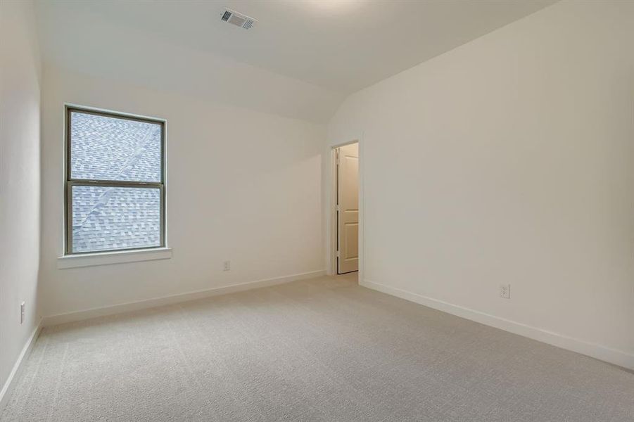 Unfurnished bedroom featuring light colored carpet and vaulted ceiling Unfurnished bedroom featuring light colored carpet and vaulted ceiling