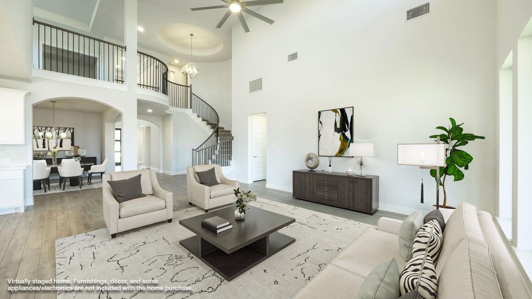 Living area featuring stairway, light wood finished floors, a chandelier, ceiling fan, and arched walkways Living area featuring stairway, light wood finished floors, a chandelier, ceiling fan, and arched walkways