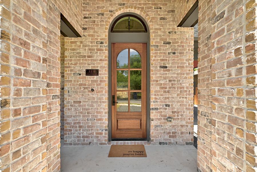 A graceful arched entryway welcomes you with timeless brick construction and a beautiful wood and glass door. A graceful arched entryway welcomes you with timeless brick construction and a beautiful wood and glass door.