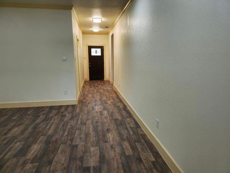 Corridor featuring crown molding and dark hardwood / wood-style floors