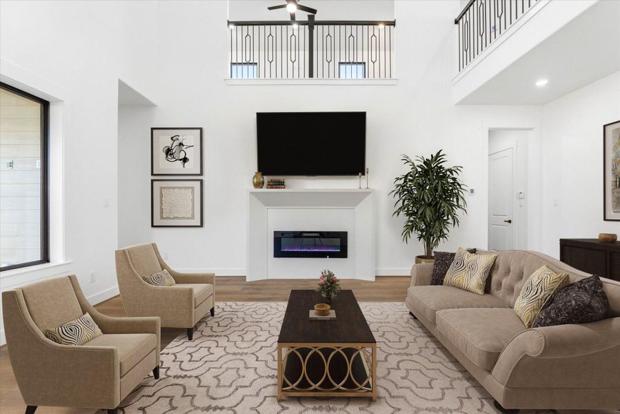 The spacious living room features soaring 21-foot ceilings, a large ceiling fan, and a sleek electric fireplace. (Virtually Staged)