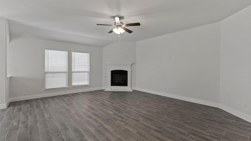 Unfurnished living room with wood tiled floors, a glass covered fireplace, and ceiling fan