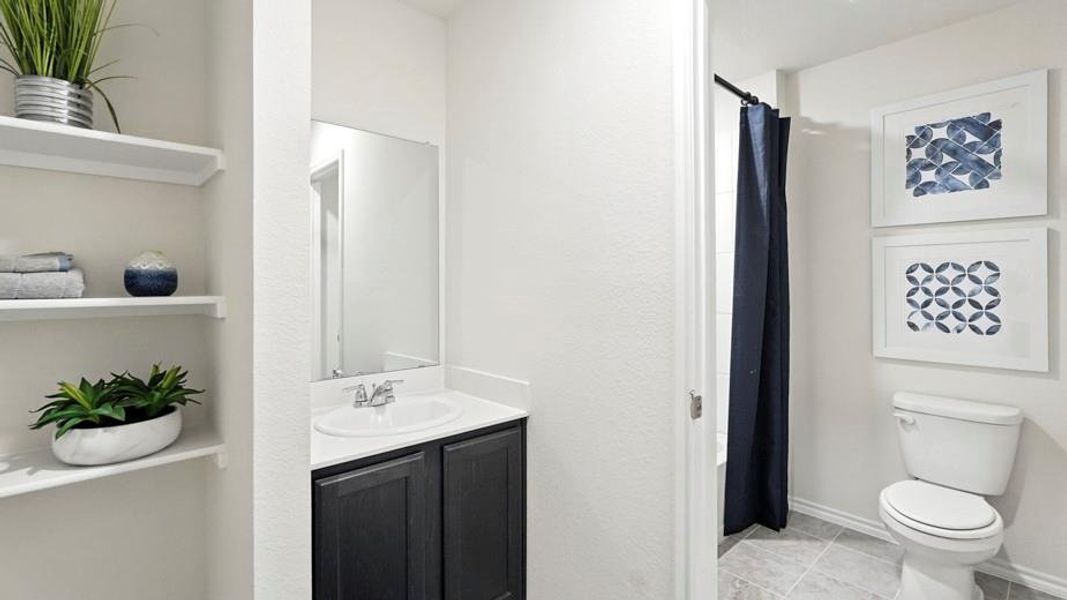 Bathroom featuring vanity, a shower with curtain, and light tile patterned floors Bathroom featuring vanity, a shower with curtain, and light tile patterned floors