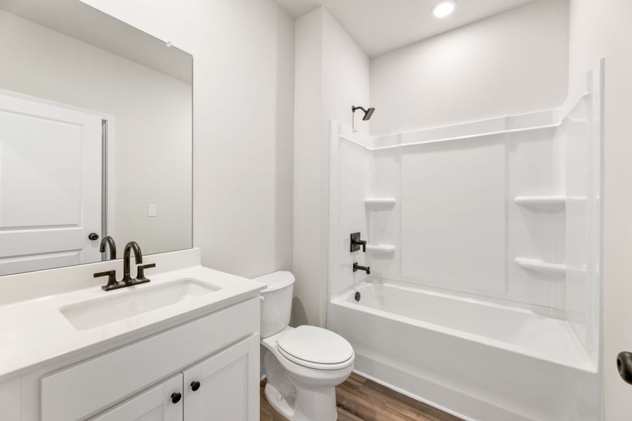 A bathroom with a tub toilet and sink. A bathroom with a tub toilet and sink.