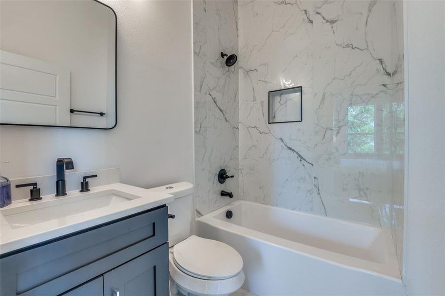 Full bathroom featuring vanity, toilet, and tiled shower / bath