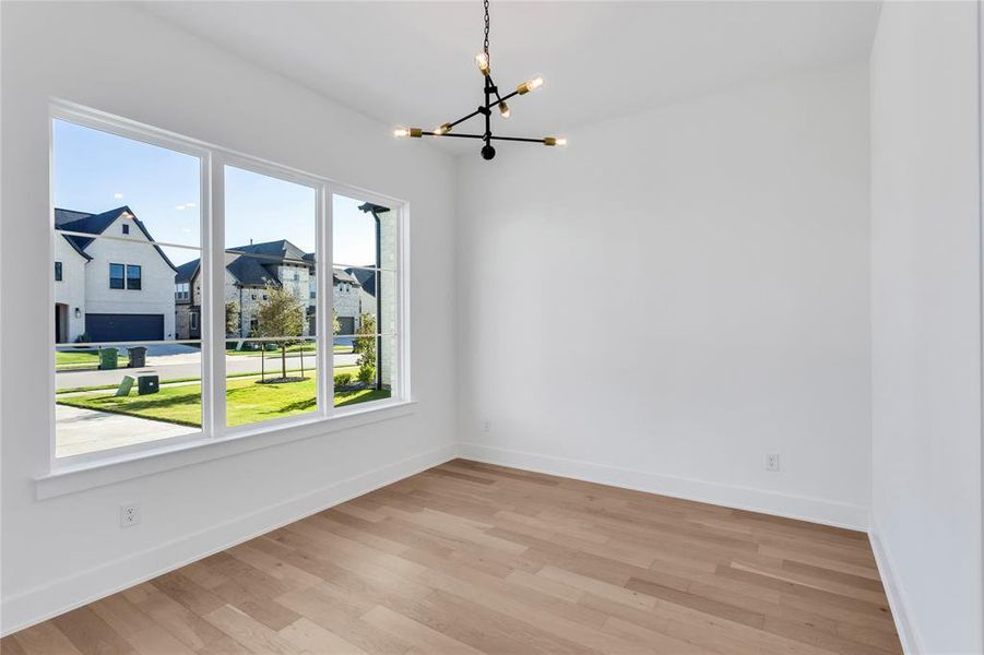 Unfurnished dining area with wood finished floors and a chandelier