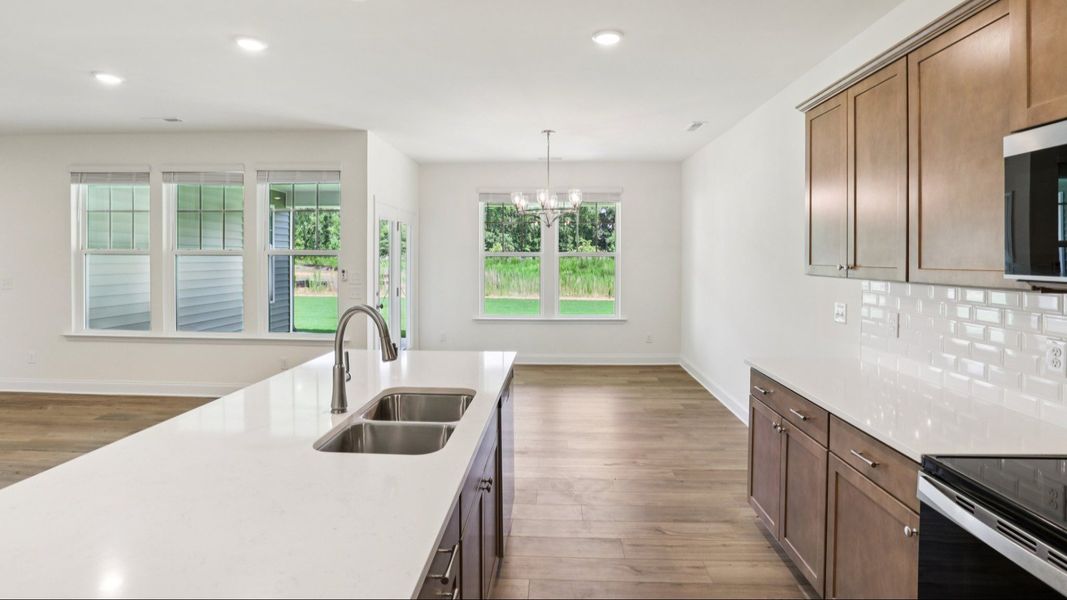 Pendleton home plan open concept kitchen with large island and abundant cabinetry overlooking family and breakfast Pendleton home plan open concept kitchen with large island and abundant cabinetry overlooking family and breakfast